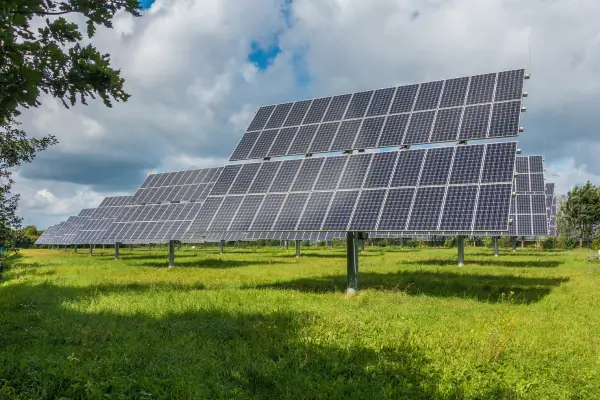 Painéis solares em um campo aberto, ilustrando como investir em energia solar vale a pena e proporciona economia com energia solar a longo prazo.